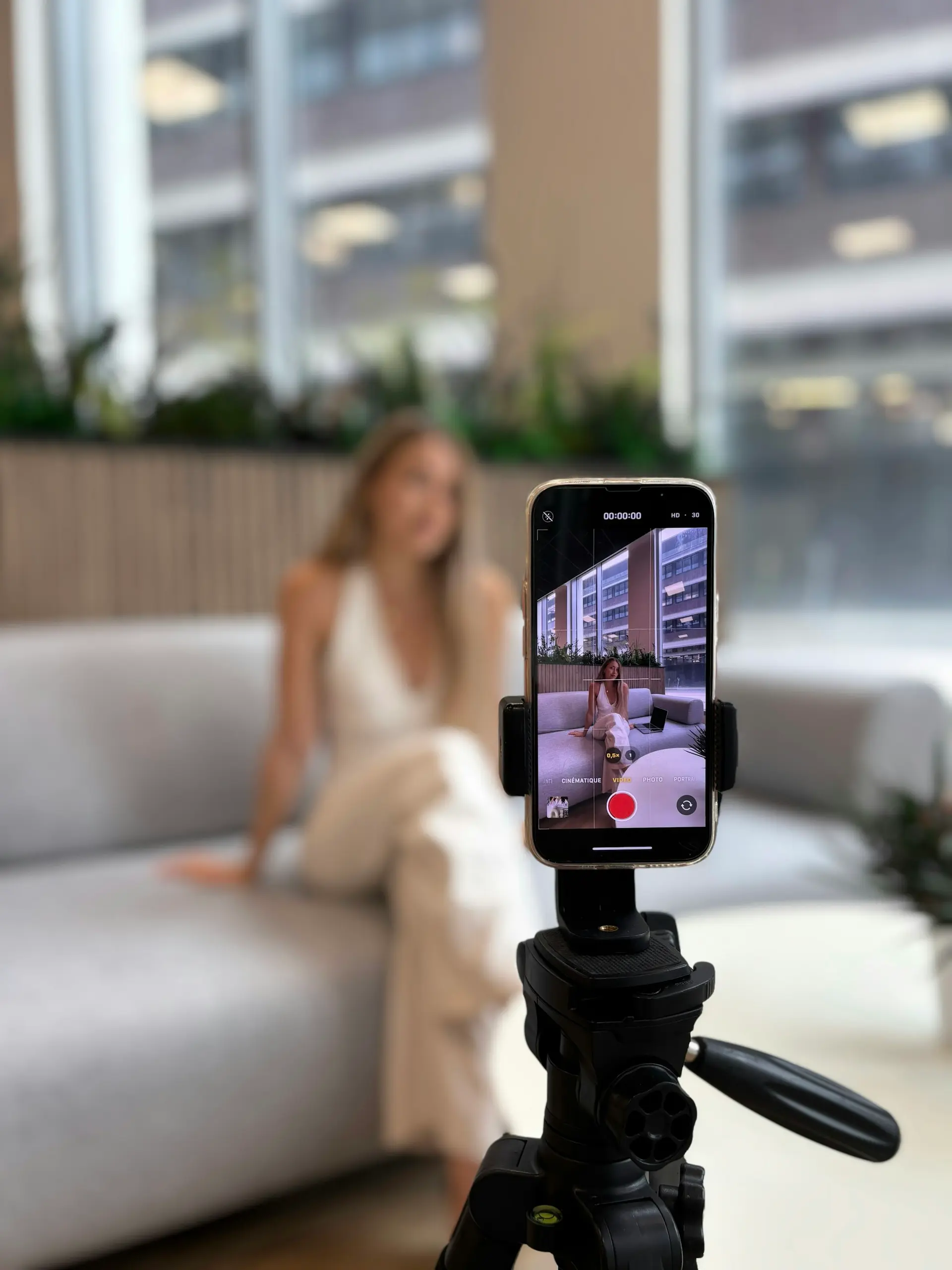 Woman recording herself on a smartphone tripod