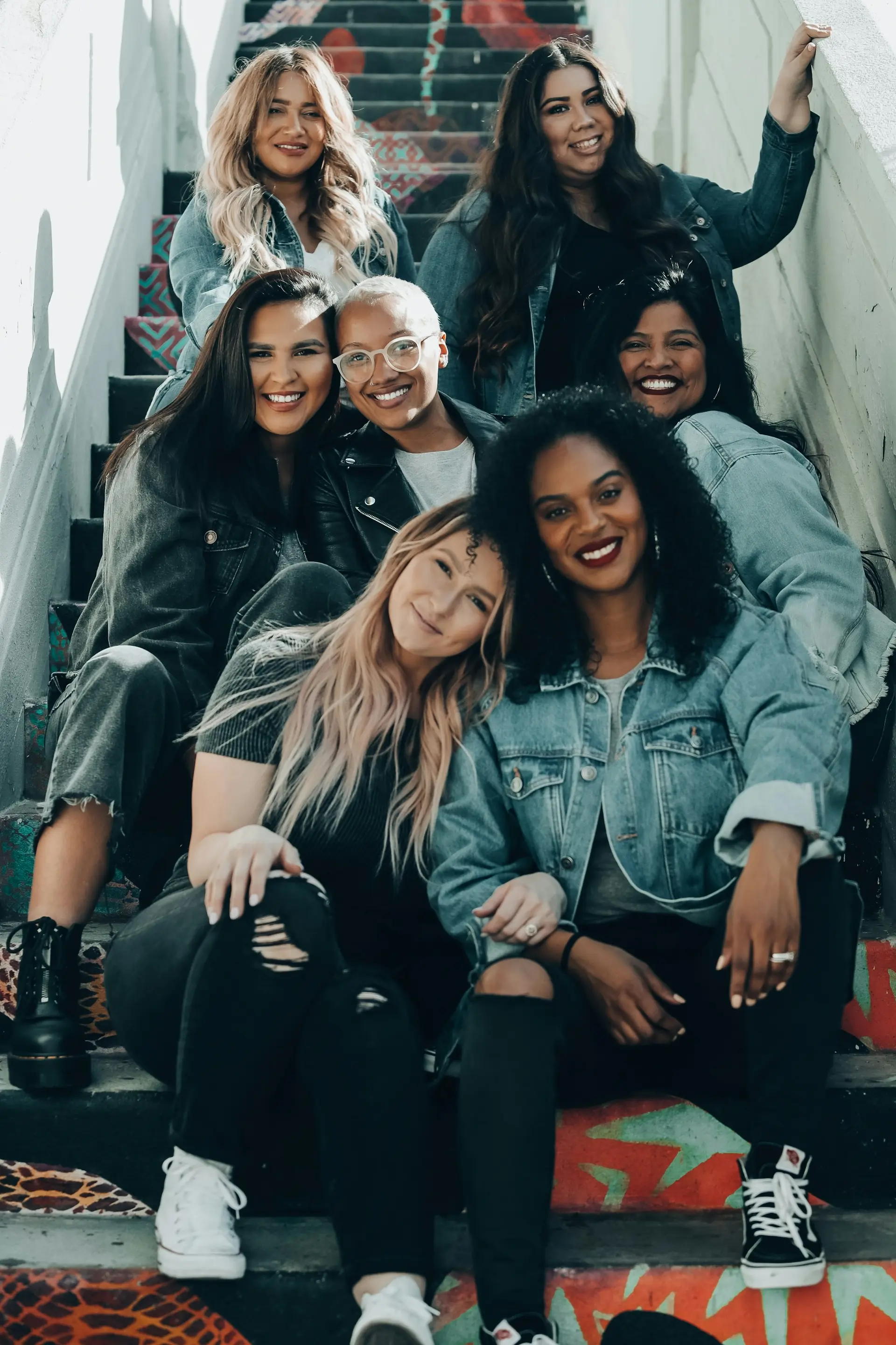 Seven women sitting on painted stairs