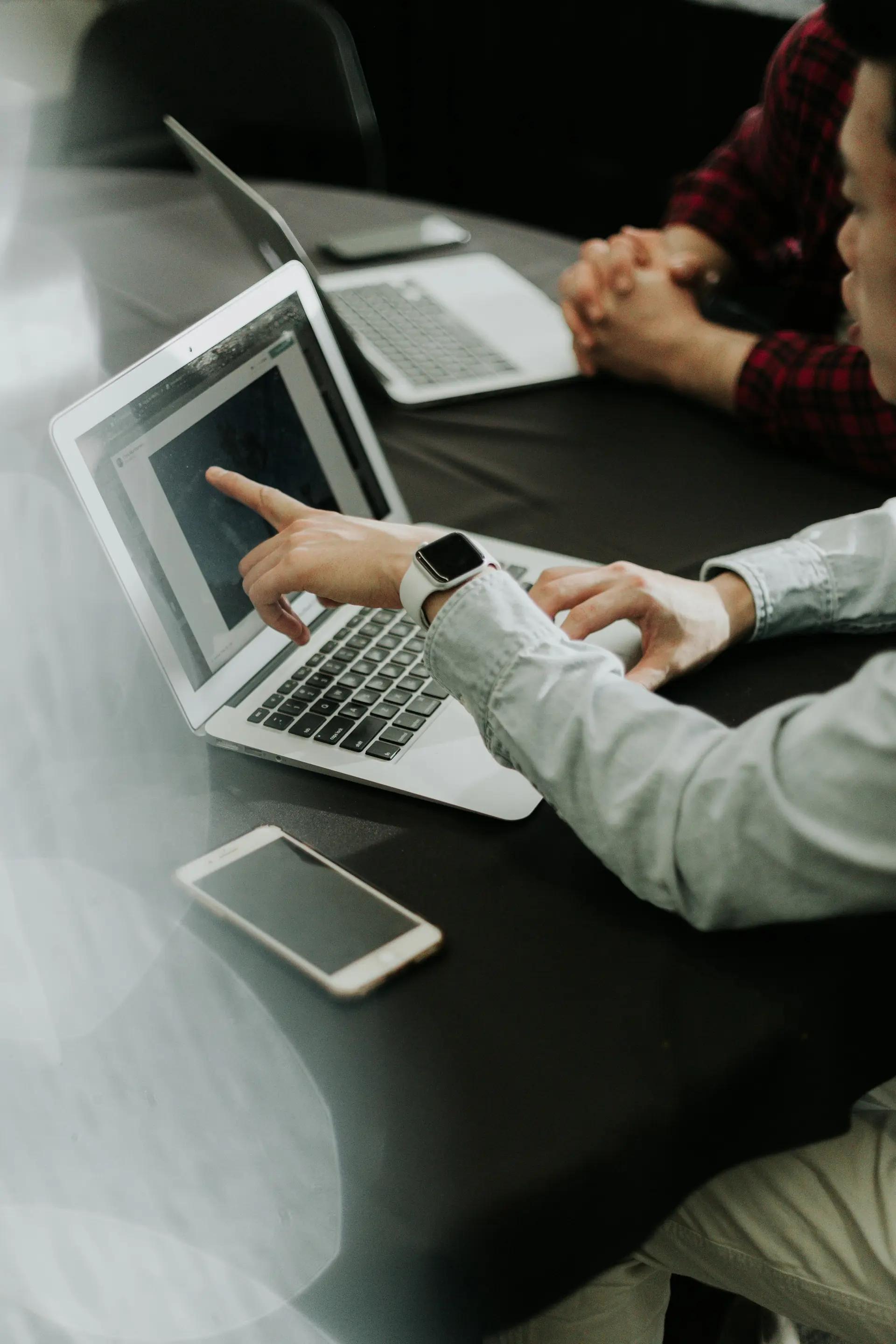 Two people at a table with laptops
